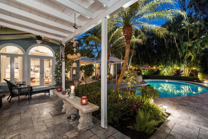 Outdoor patio with large pool and lush landscaping