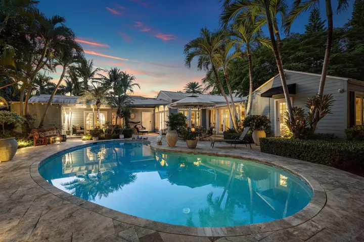 Outdoor patio with large pool and lush landscaping