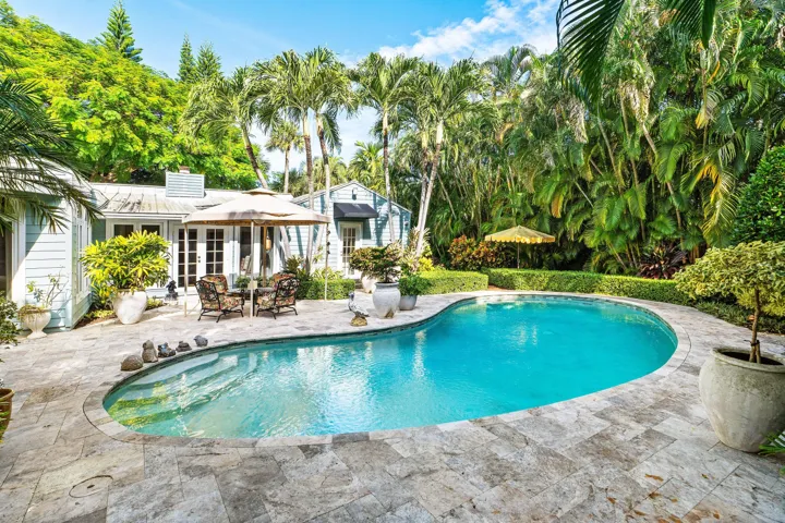 Outdoor patio with large pool and lush landscaping