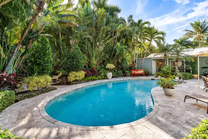 Outdoor patio with large pool and lush landscaping