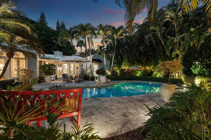 Outdoor patio with large pool and lush landscaping