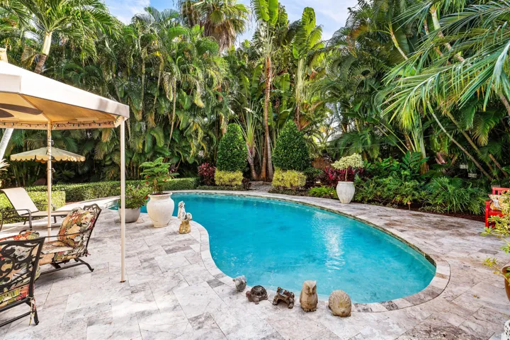 Outdoor patio with large pool and lush landscaping