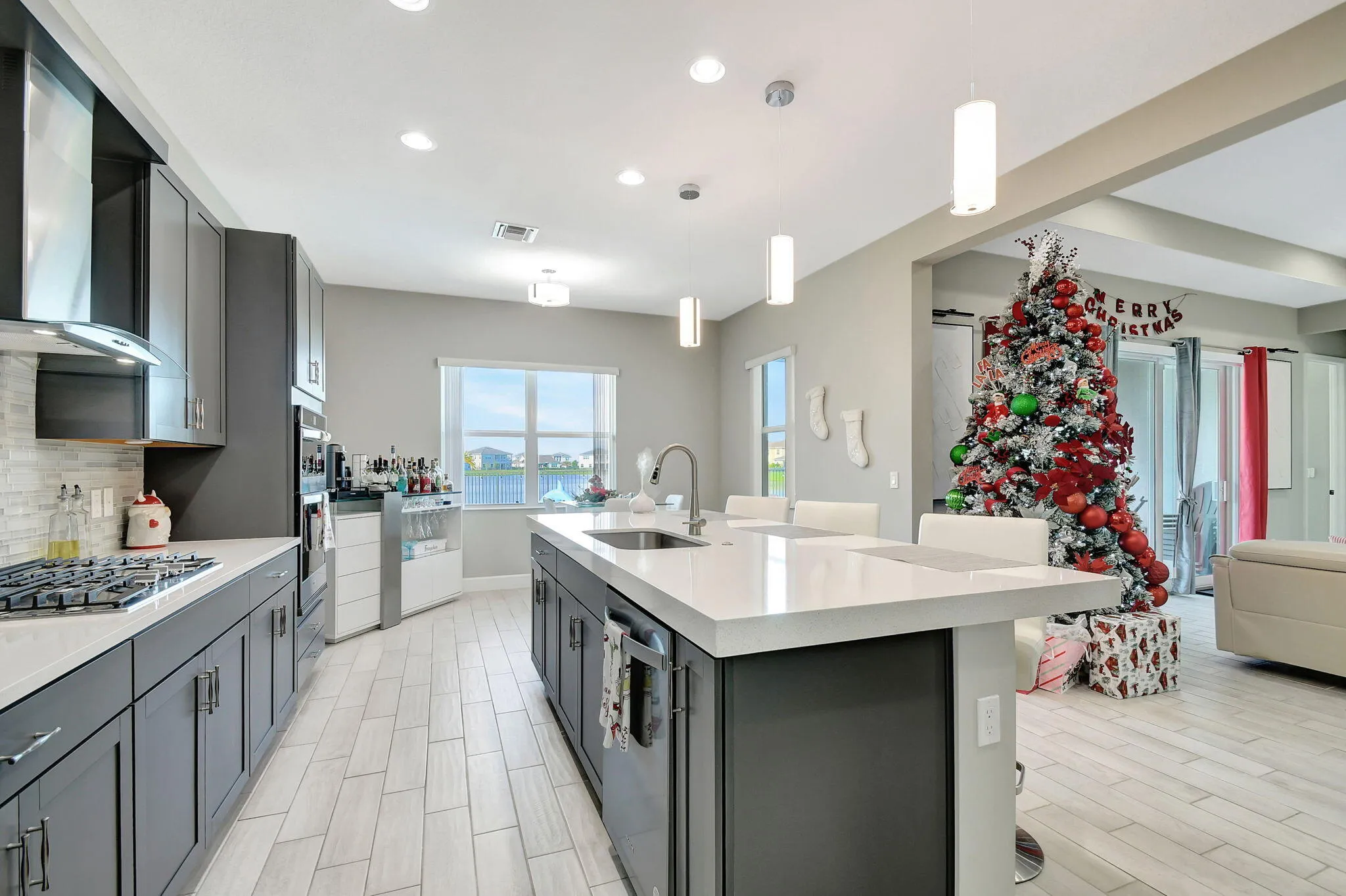 Kitchen featuring an island with a sink, white countertops, gray cabinetry, and wood-finish flooring