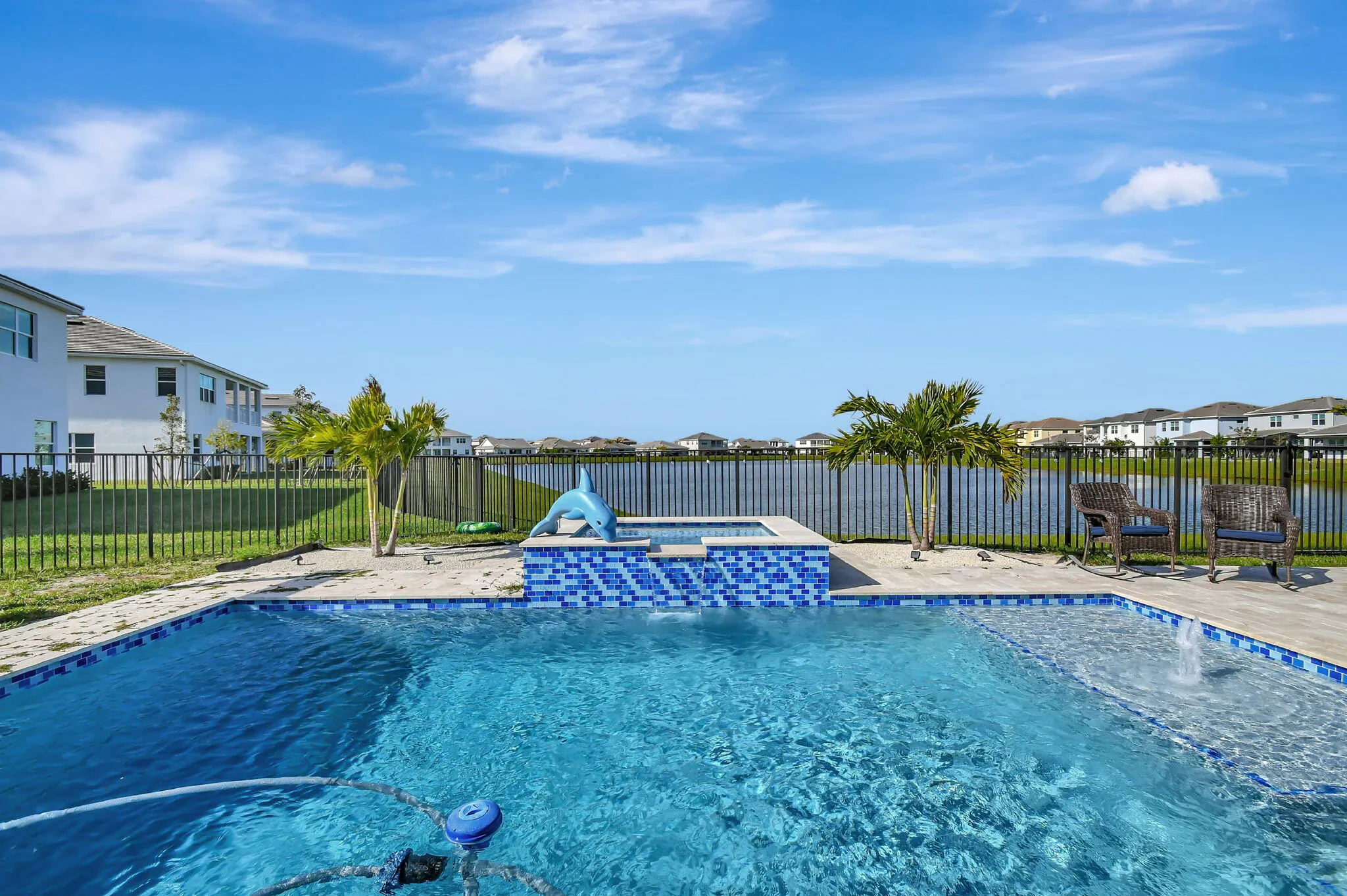 Outdoor swimming pool featuring a tiled spa with a dolphin water feature