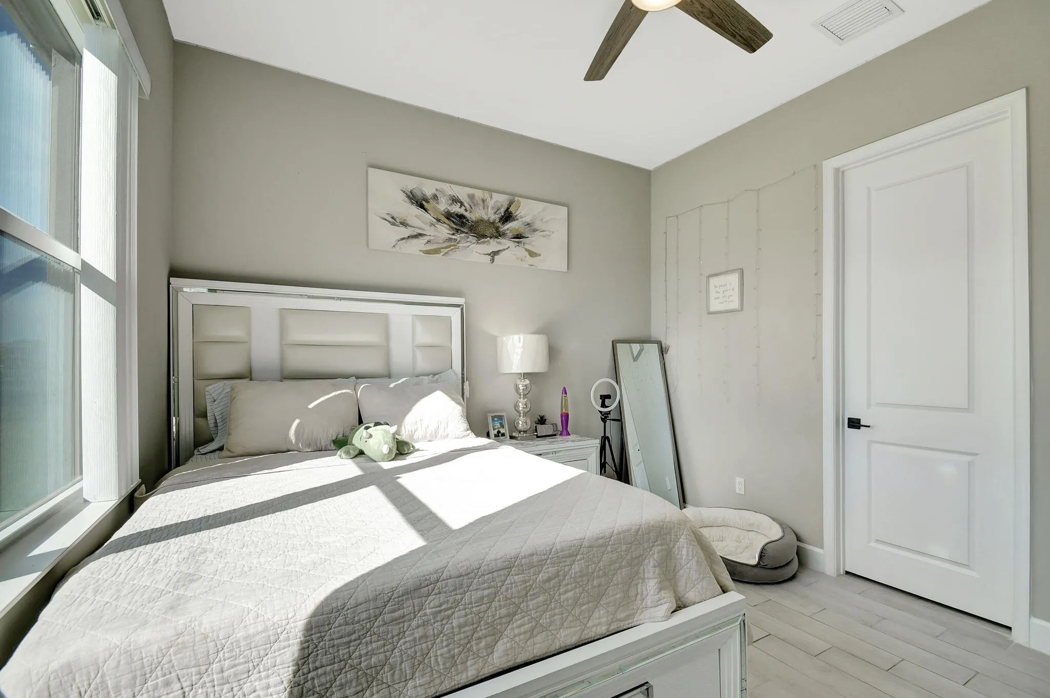 Recessed window with natural light, wood-look flooring, ceiling fan, and paneled interior door