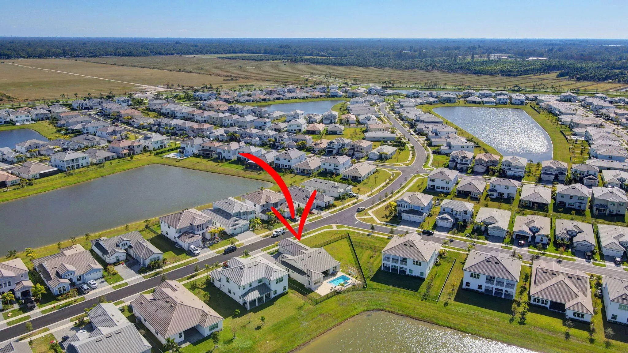 Residential property with a private swimming pool, located within a community featuring multiple ponds and a paved road network