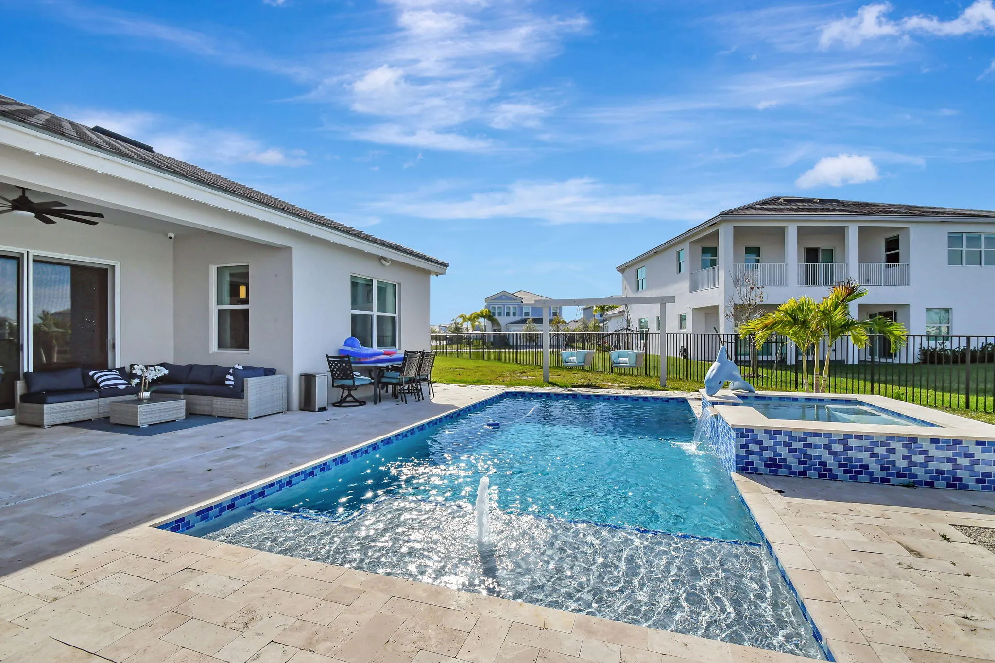 Outdoor living space featuring a rectangular pool with an integrated spa, paver patio, and sliding glass door access