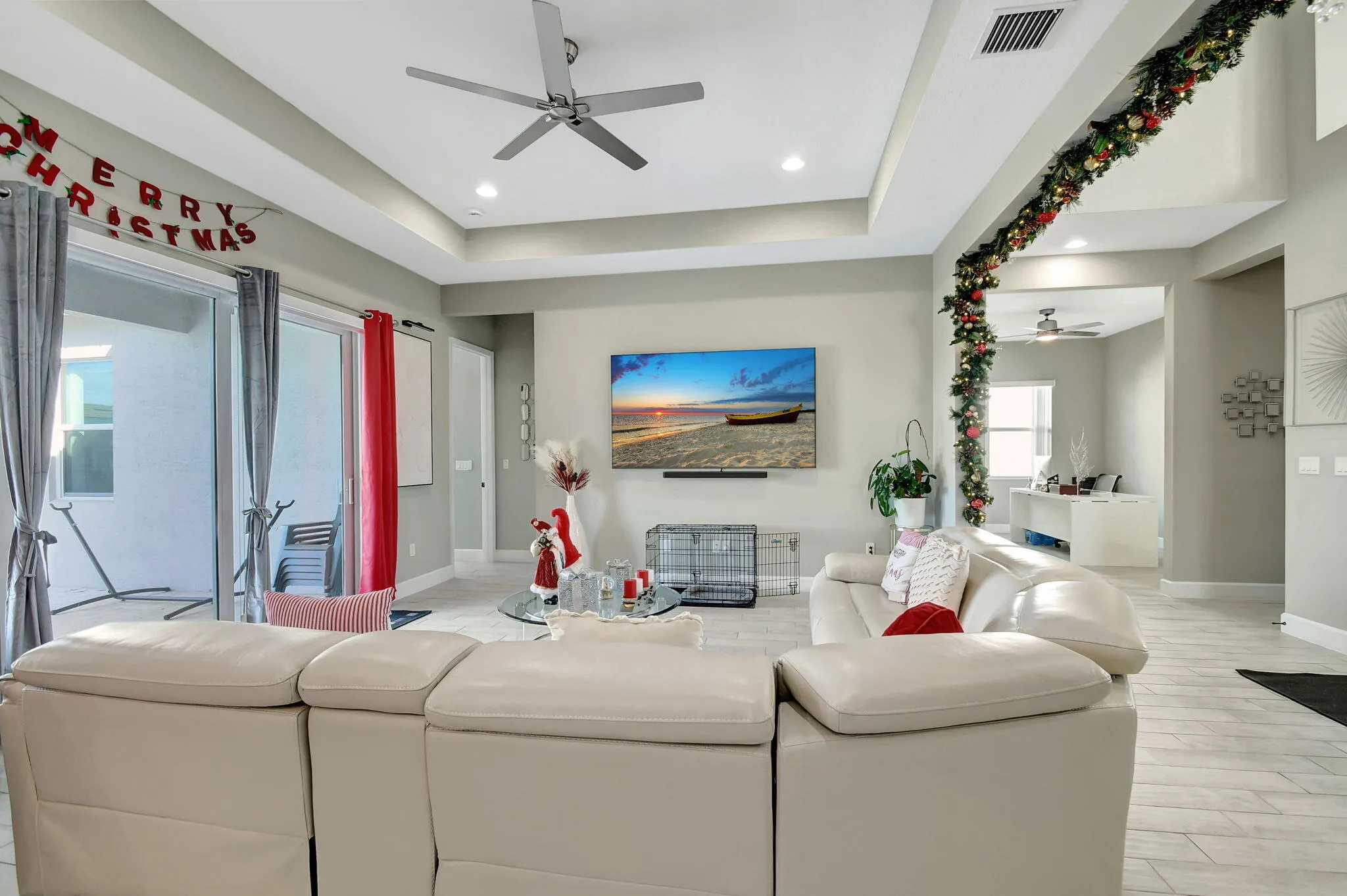 Recessed lighting, ceiling fan, sliding glass doors, tray ceiling, and light-toned flooring