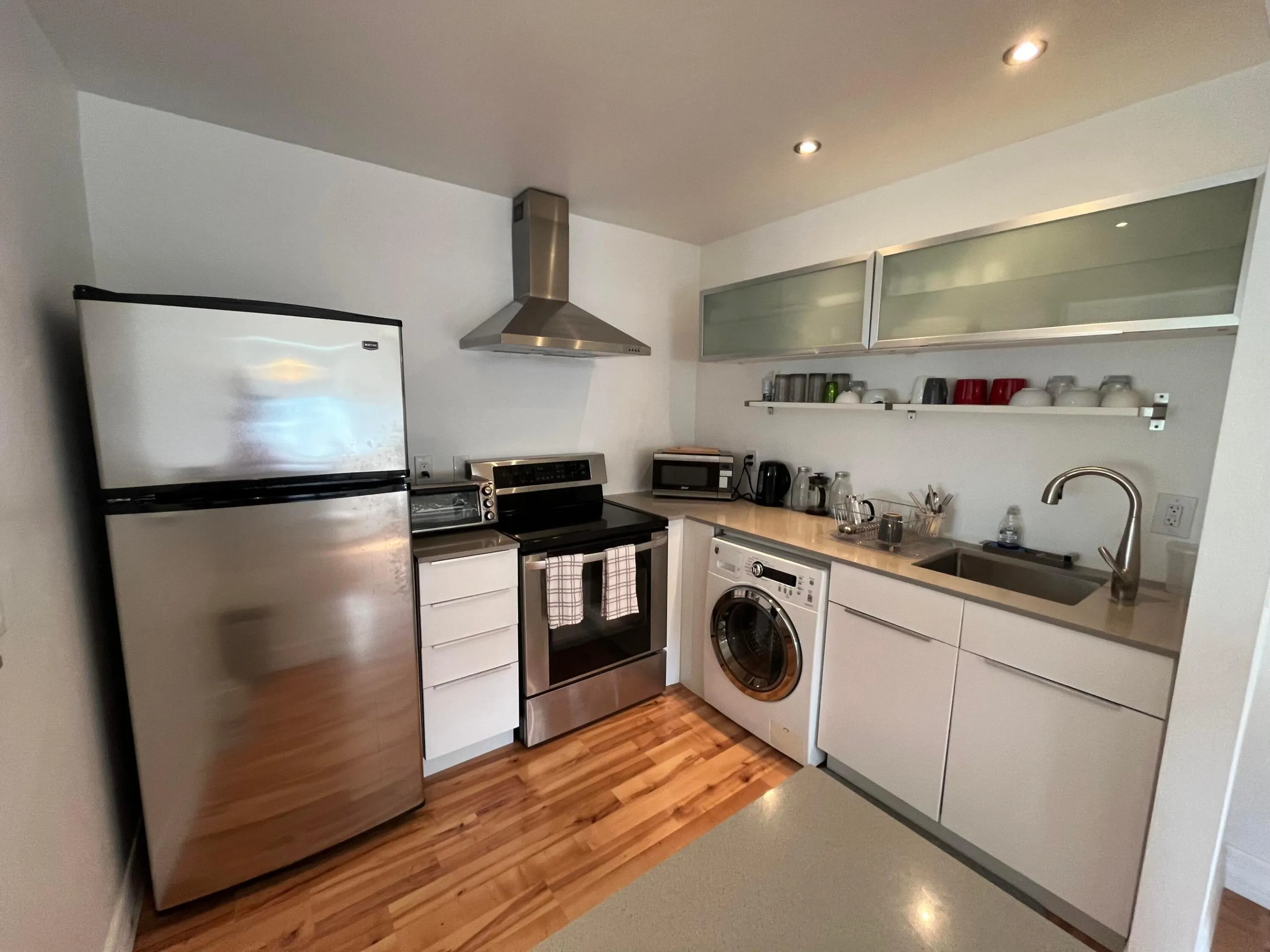 stainless appl.'s in the kitchen, with a washing machine under counter.