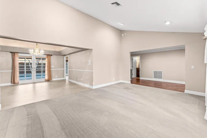 View from living room into hallway, dining room, and patio/pool area