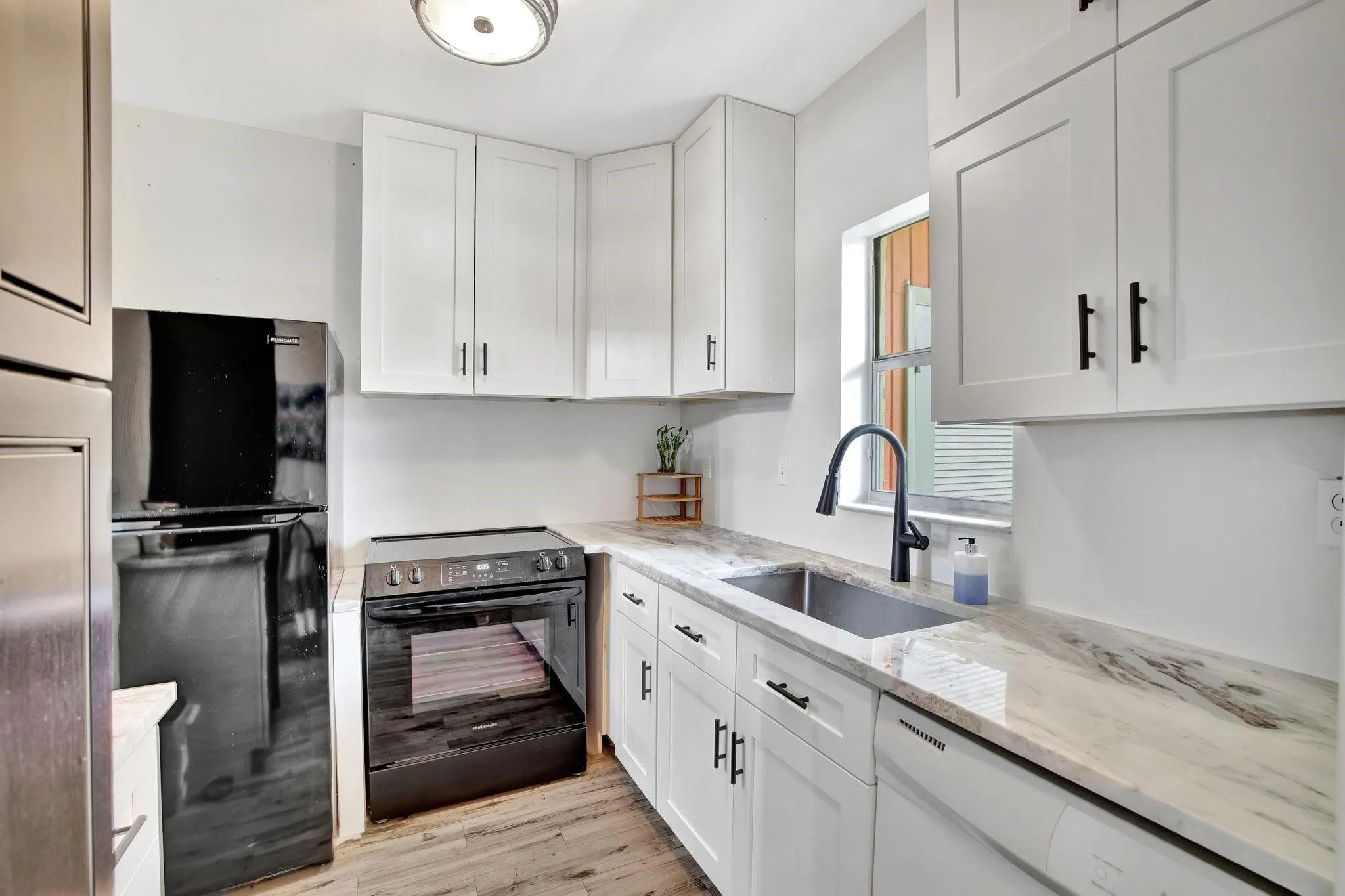 The Kitchen features white shaker cabinets with abundant storage, granite countertops, and black appliances