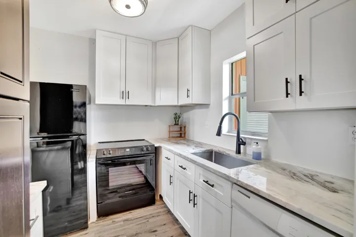 The Kitchen features white shaker cabinets with abundant storage, granite countertops, and black appliances