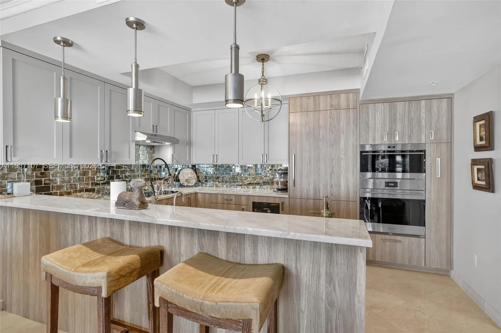 Spectacular kitchen w/ custom bleached walnut veneer cabinetry by renowned Chicago based millworker. Grain matches from top to bottom. Taj mahal quartzite. Wolf induction cooktop & double oven (w/ microwave / convenction at top oven), Sub Zero Refrigerator & Beverage Cooler, Miele Dishwasher. Counter seating. Antiqued mirror backsplash