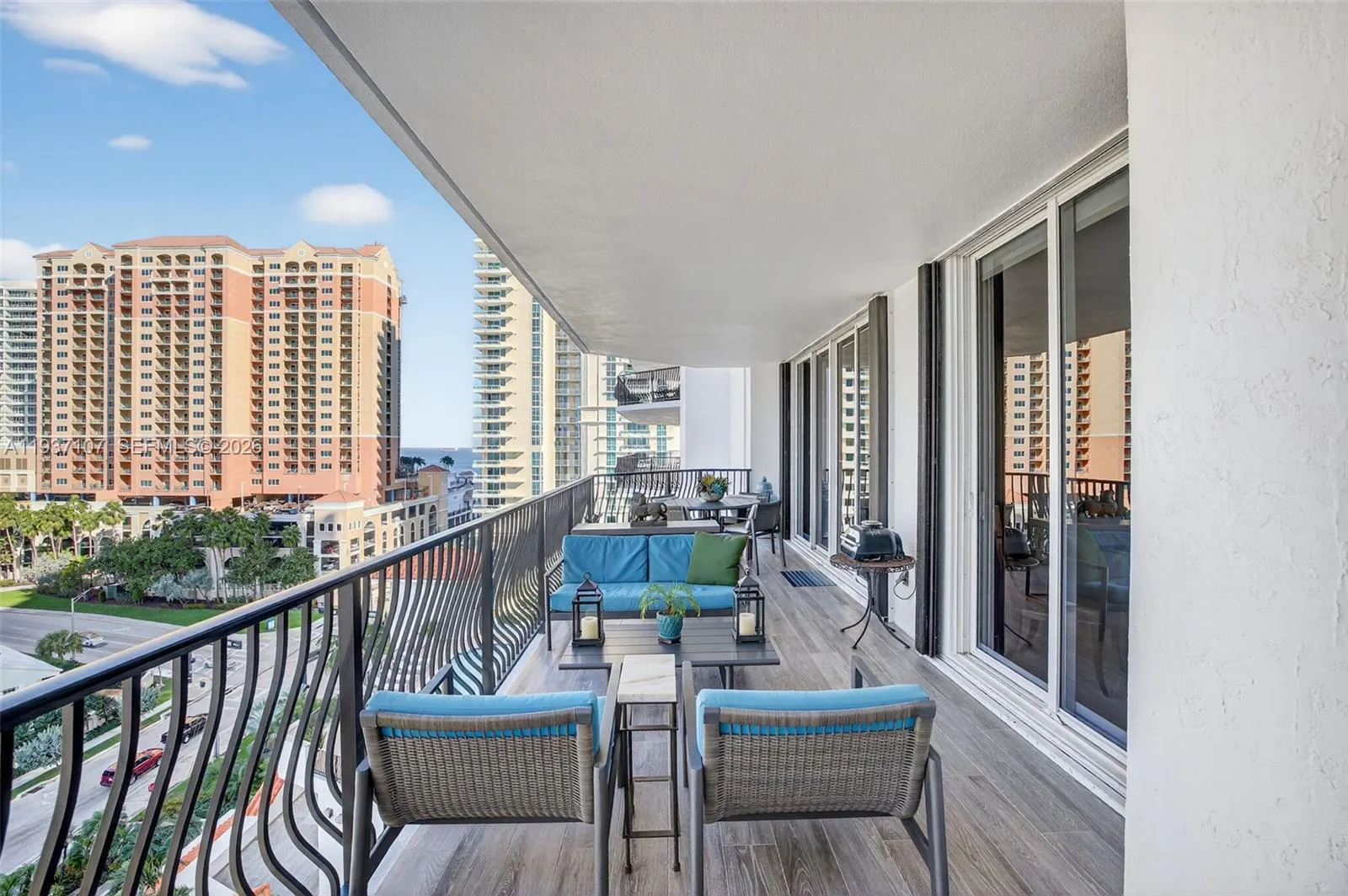 Long Balcony w/ new plank tile flooring. 3 sets of slides lead to balcony, from Family Rm, Guest Rm & Primary Bedroom
