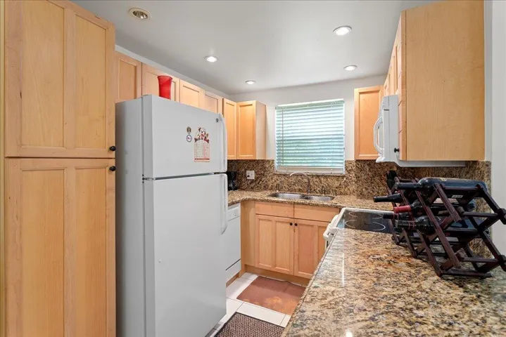 Granite counters , wood cabinets and garden view from sink
