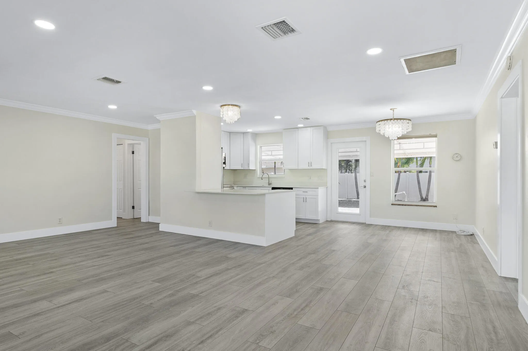 Bright open-concept living with new floors, fresh paint, and updated lighting.