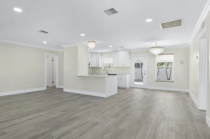 Bright open-concept living with new floors, fresh paint, and updated lighting.