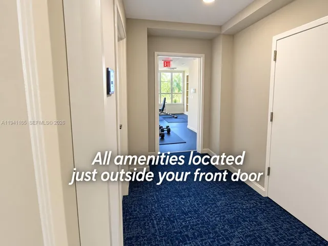 Hallway featuring blue patterned carpet, recessed lighting, and multiple solid-core doors