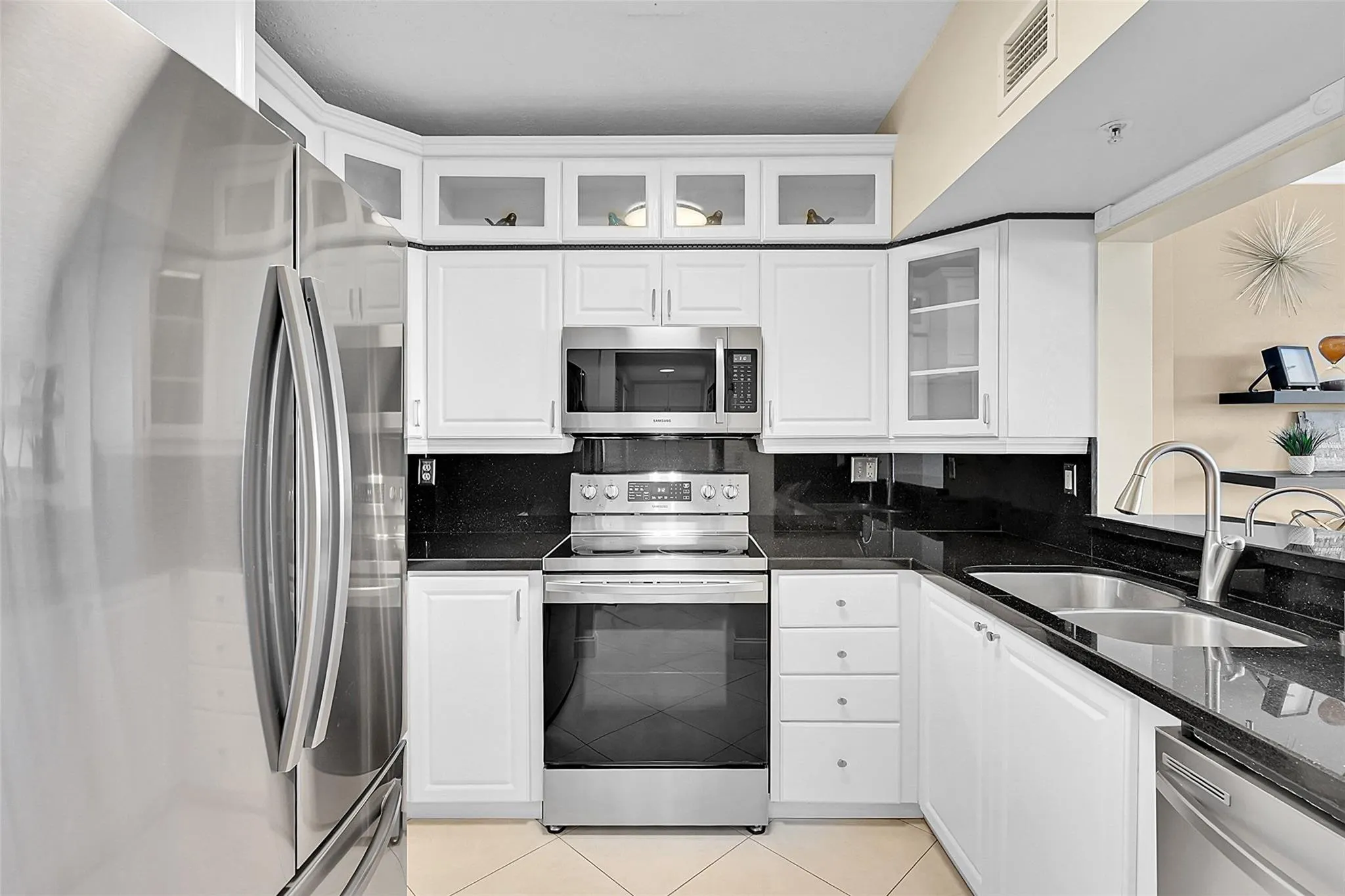 Bright kitchen featuring white cabinetry, stainless steel appliances, and a functional layout for everyday living.