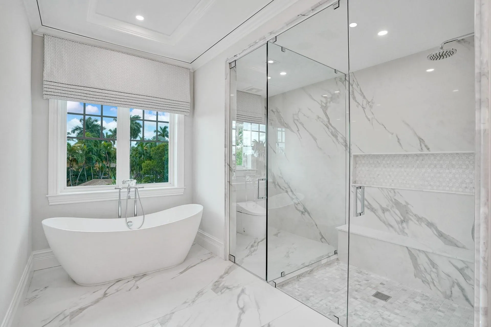 The primary suite boasts separate his-and-hers bathrooms; her bathroom features a spa-like soaking tub, makeup vanity, and a spacious walk-in closet.