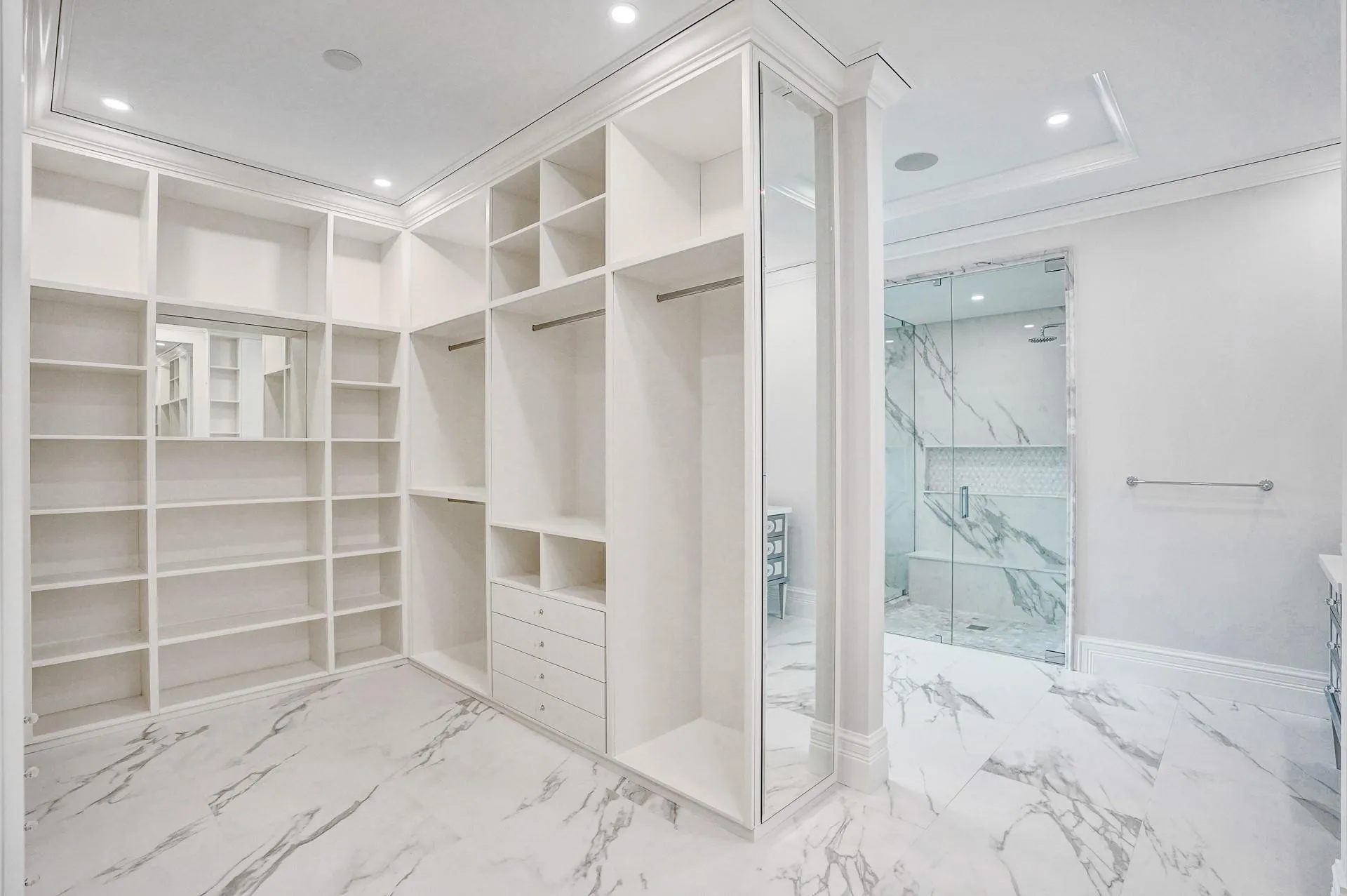 The primary suite boasts separate his-and-hers bathrooms; her bathroom features a spa-like soaking tub, makeup vanity, and a spacious walk-in closet.