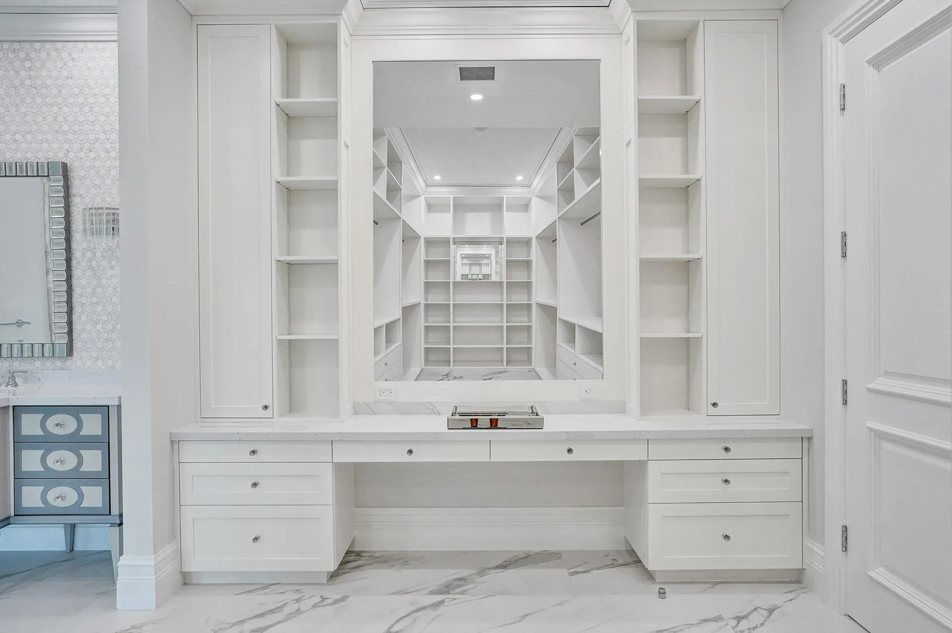 The primary suite boasts separate his-and-hers bathrooms; her bathroom features a spa-like soaking tub, makeup vanity, and a spacious walk-in closet.
