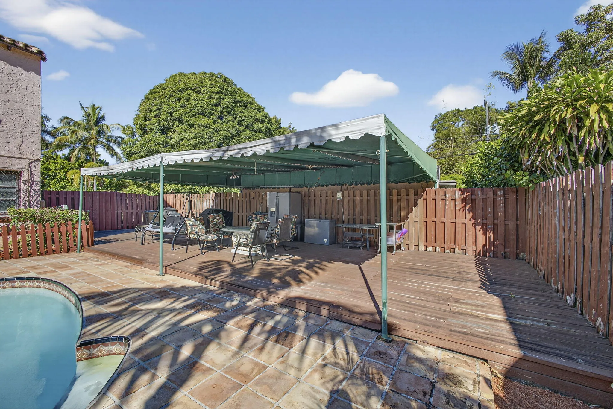 The awning covers a large section of the deck/pool area