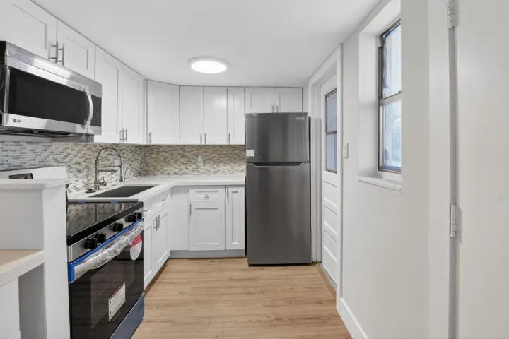 New stainless steel appliances, white shaker cabinets, quartz countertops