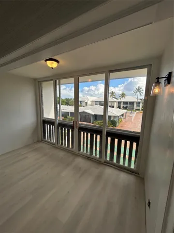 Balcony/ Florida Room/ Office space connected to Living/ Family room. Sliding doors were removed to connect the space for more usage. Window treatments / dividers can be added to separate the rooms.Brand new flooring just installed. Custom moldings (wainscoting) / wood work throughout the unit. View from balcony/ patio/ sun room looks over the St. Lucie River, pier, club house, pool, and shuffle board.