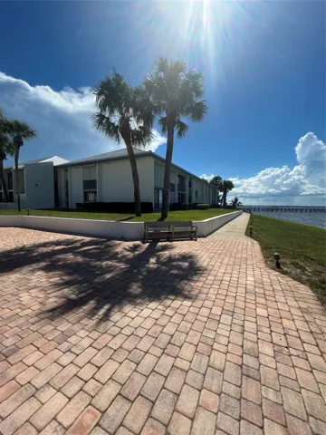 View of building from the club house/ pool/ and lounging/ picnic area/ outside gathering area in front of private beach and pier/ dock