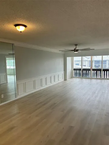 Living Room/ Family Room:Brand new flooring just installed. Custom moldings (wainscoting) / wood work throughout the unit. View from balcony/ patio/ sun room looks over the St. Lucie River, pier, club house, pool, and shuffle board.