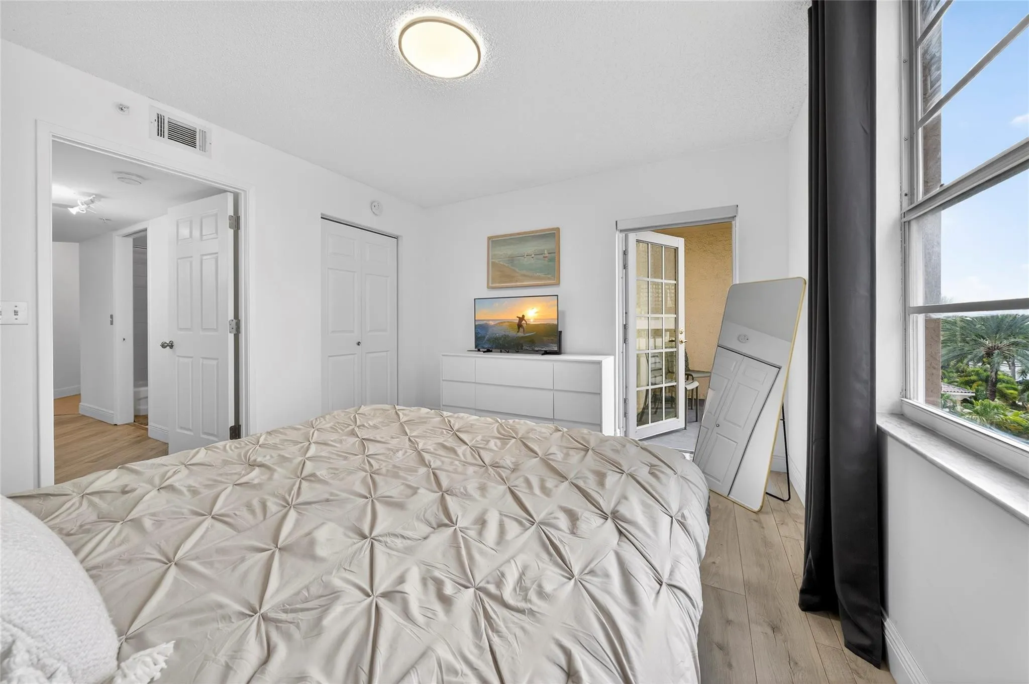 Spacious primary suite features a private patio and a recently remodeled en-suite bathroom, creating a peaceful and comfortable retreat.