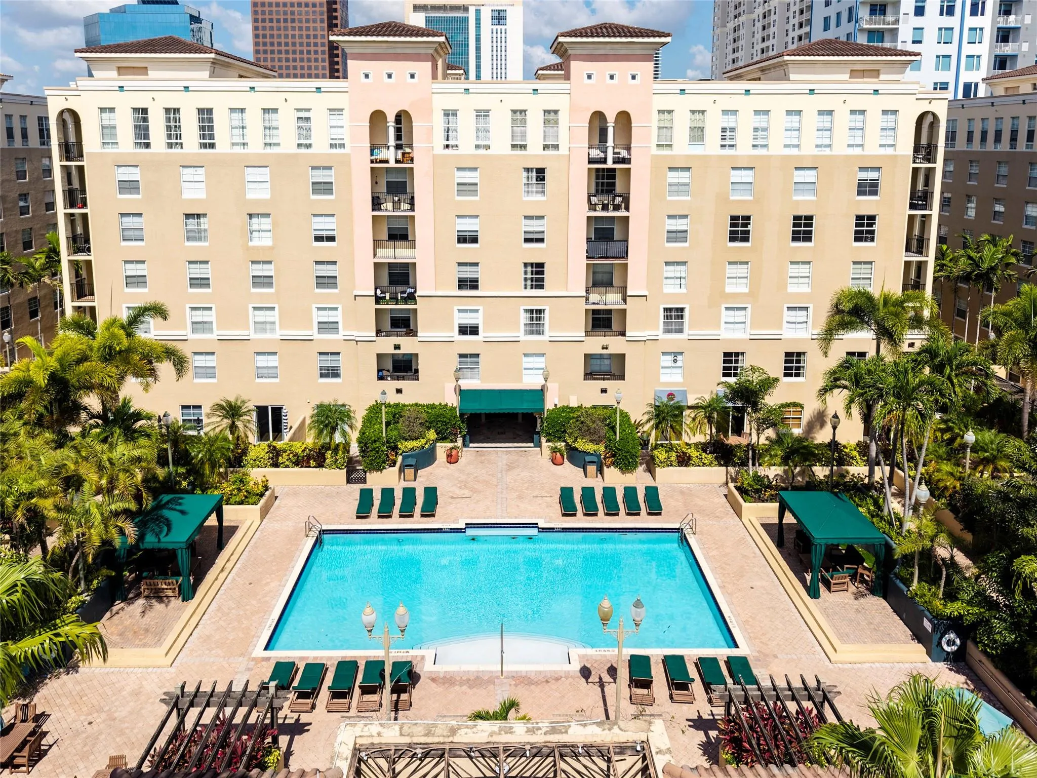 Stunning pool area surrounded by lush landscaping, featuring cabanas, a hot tub, shower, and more for ultimate relaxation.