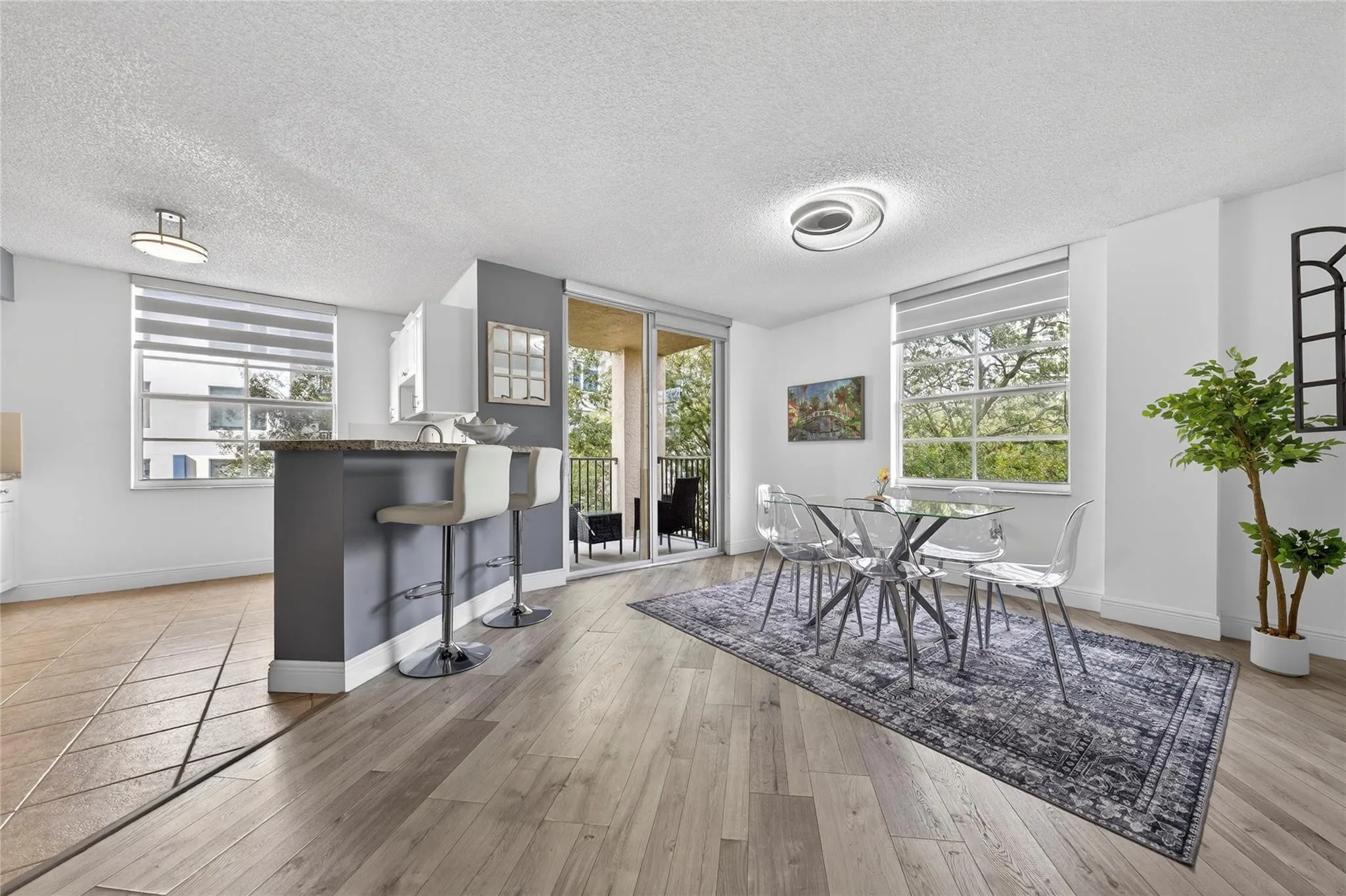 Bright, open living and dining area featuring corner-unit privacy, treetop views, and seamless access to the private balcony—perfect for everyday living and entertaining.