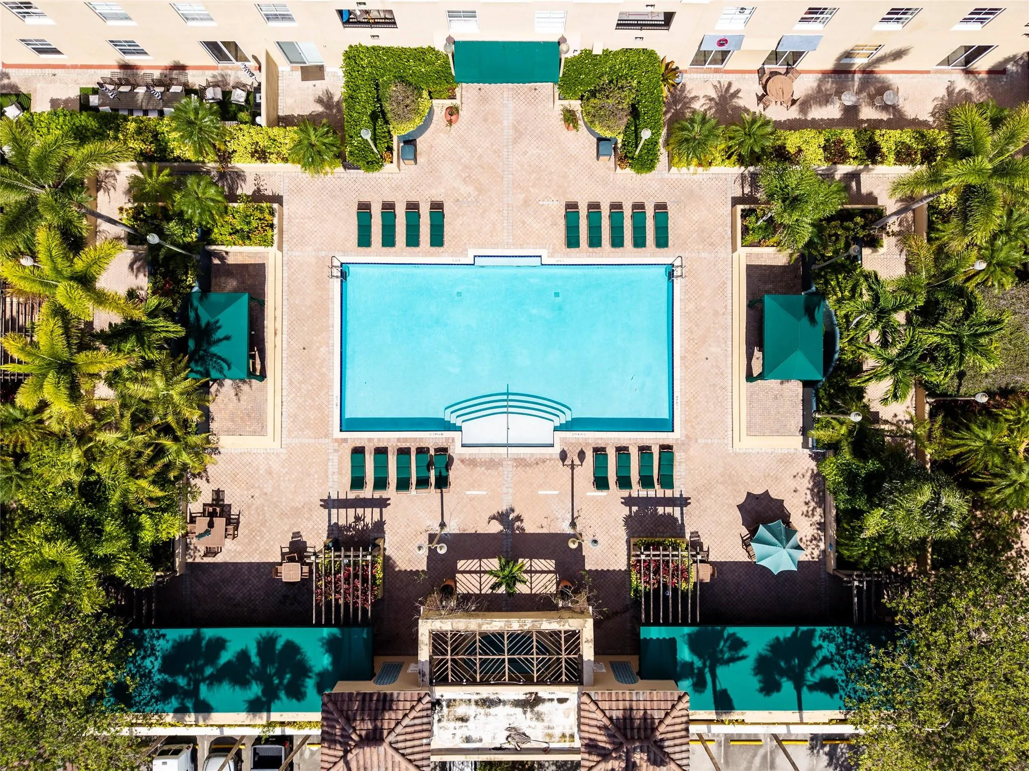 Stunning pool area surrounded by lush landscaping, featuring cabanas, a hot tub, shower, and more for ultimate relaxation.