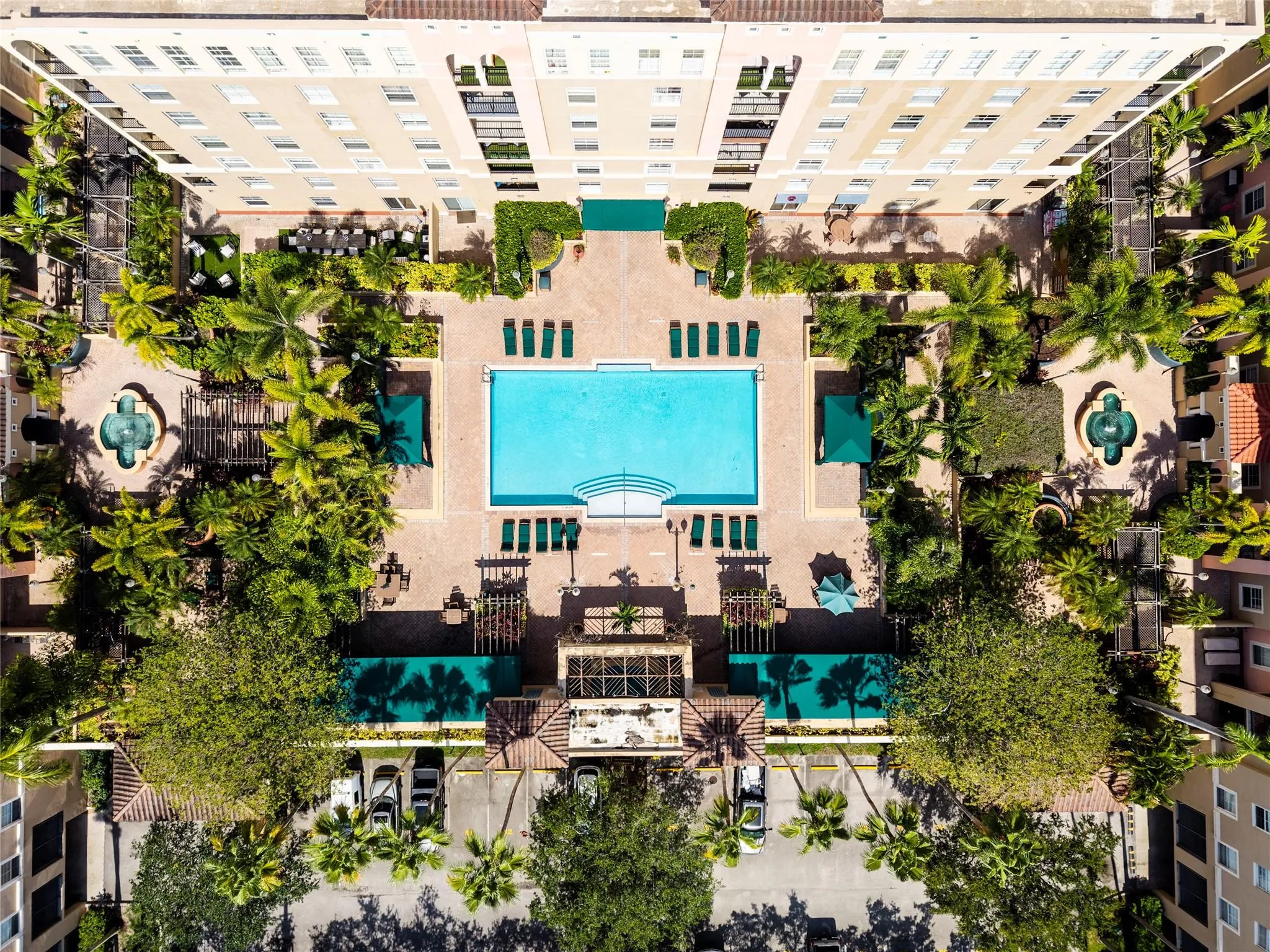 Stunning pool area surrounded by lush landscaping, featuring cabanas, a hot tub, shower, and more for ultimate relaxation.