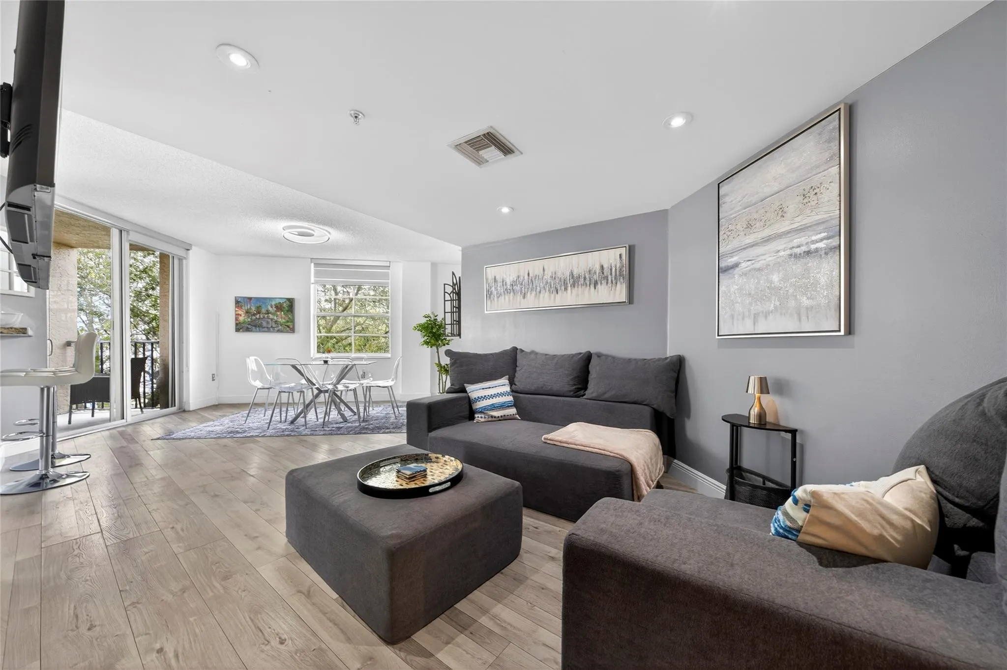 Spacious living room with an open layout, abundant natural light, and seamless flow to the dining area—ideal for relaxing or entertaining.