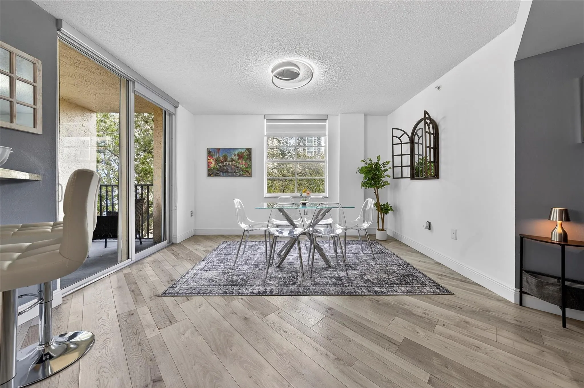 Bright, open living and dining area featuring corner-unit privacy, treetop views, and seamless access to the private balcony—perfect for everyday living and entertaining.