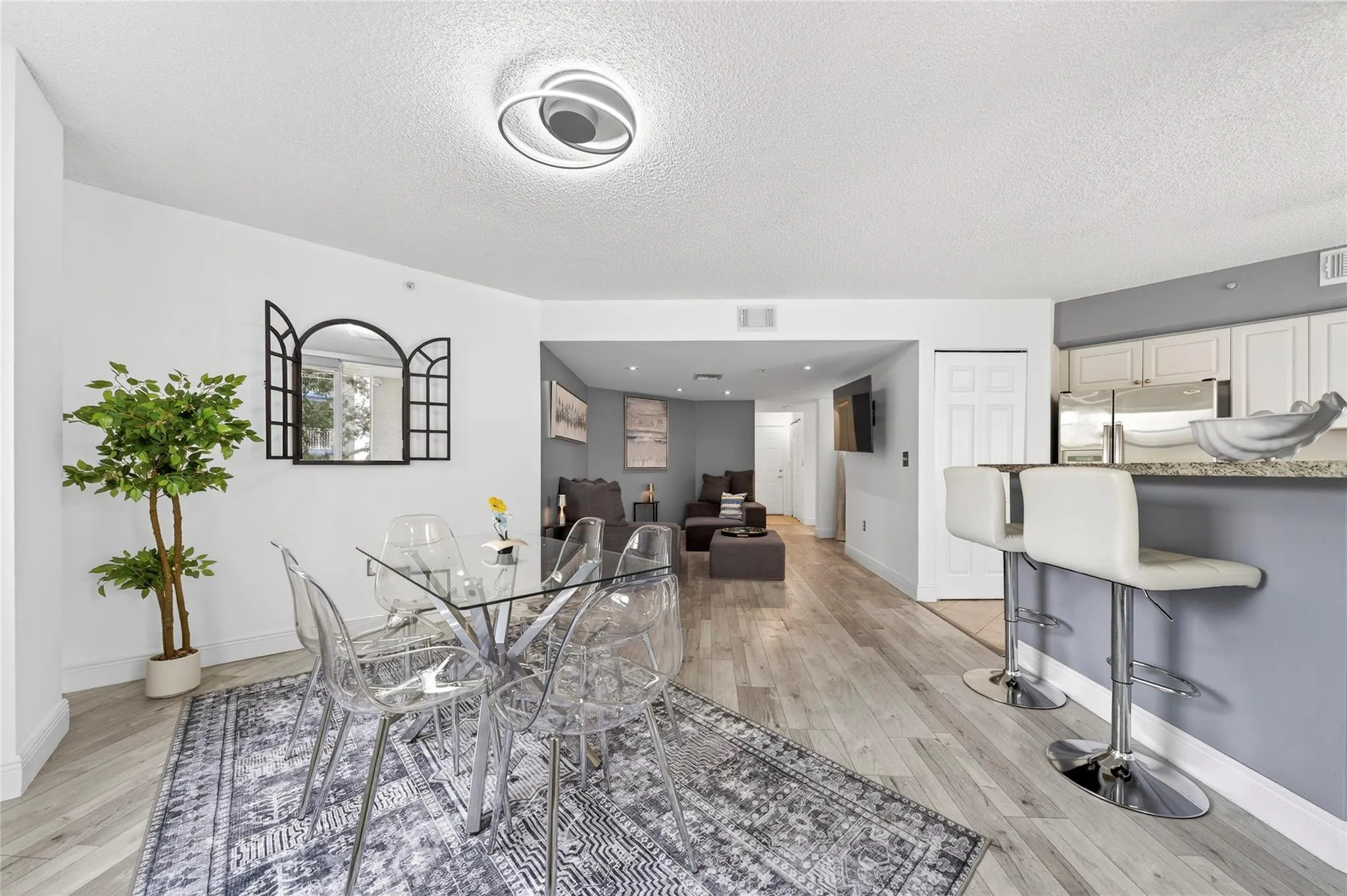 Bright, open living and dining area featuring corner-unit privacy, treetop views, and seamless access to the private balcony—perfect for everyday living and entertaining.