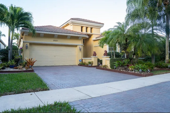 Welcoming front exterior with a paved driveway and mature landscaping