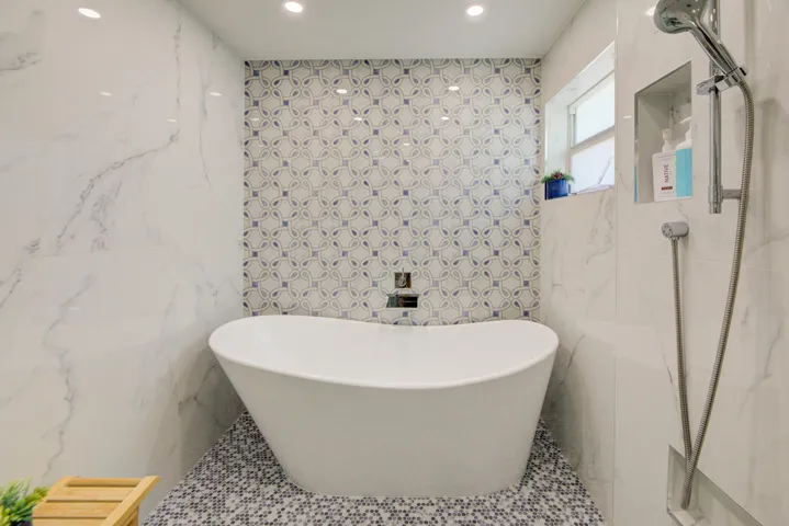 Beautiful new "super shower" with soaking tub and gorgeous tiling in this primary suite bathroom.
