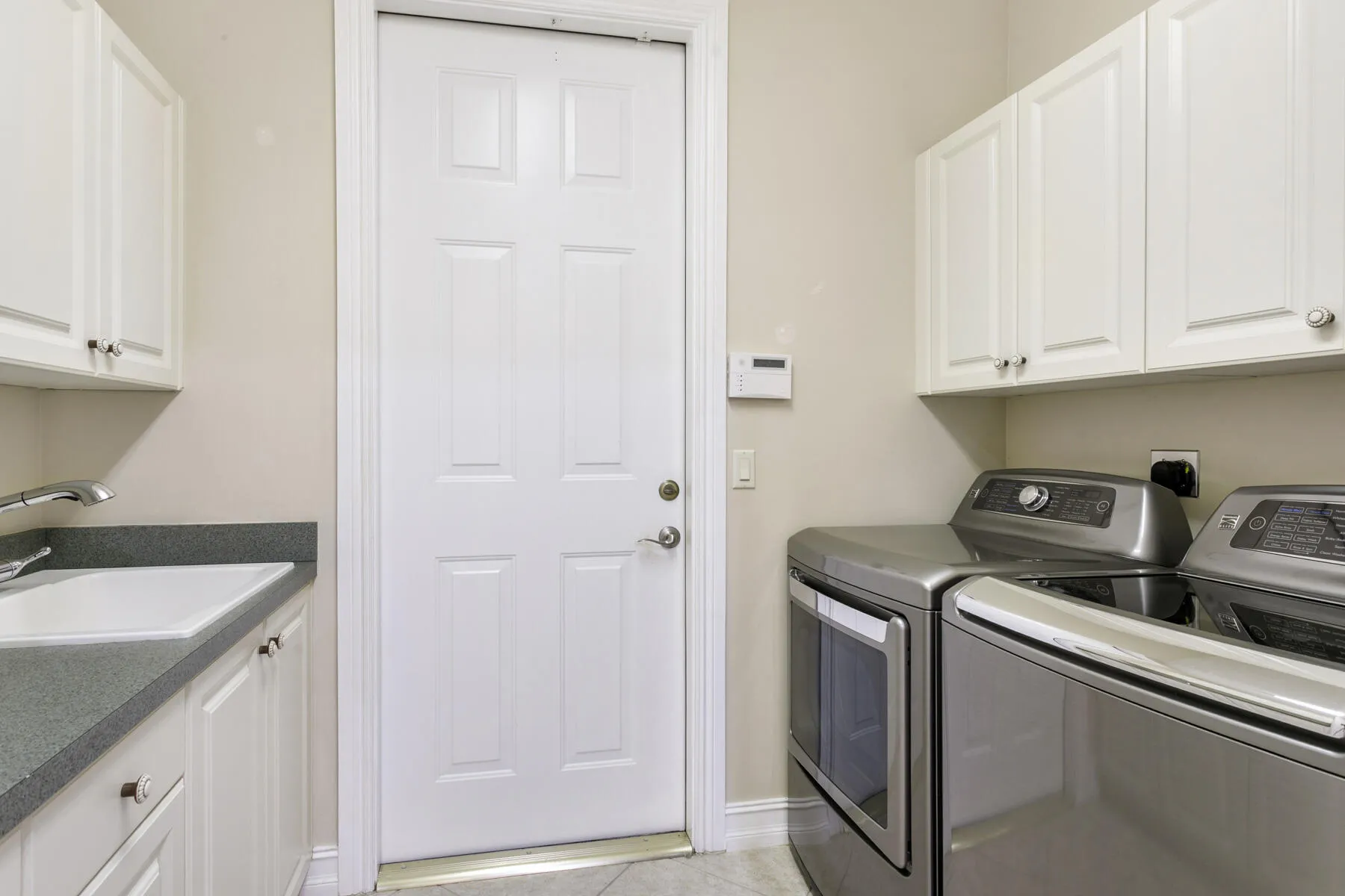 Newer appliances and laundry tub with access to/from garage
