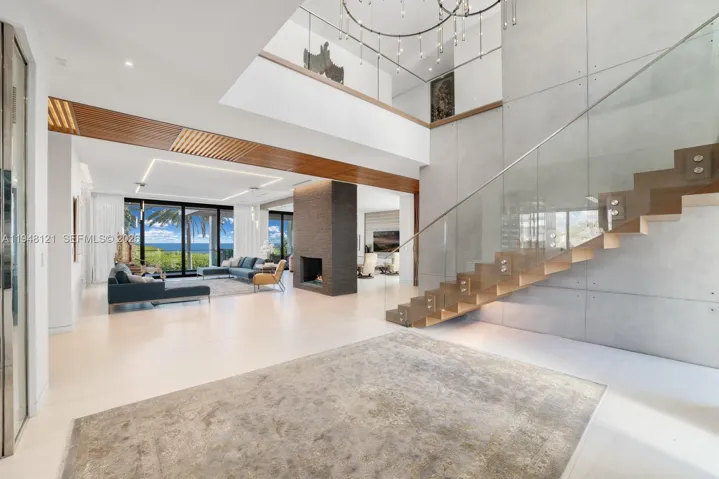 Dramatic double-height entry with sleek staircase and trending slatted wood feature.