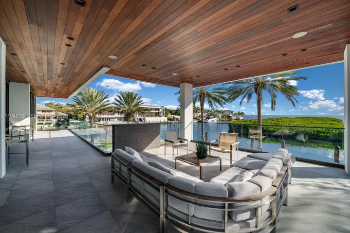 Lounge area overlooking pool and water views featuring Brazilian hardwood IPE for outdoor ceilings.