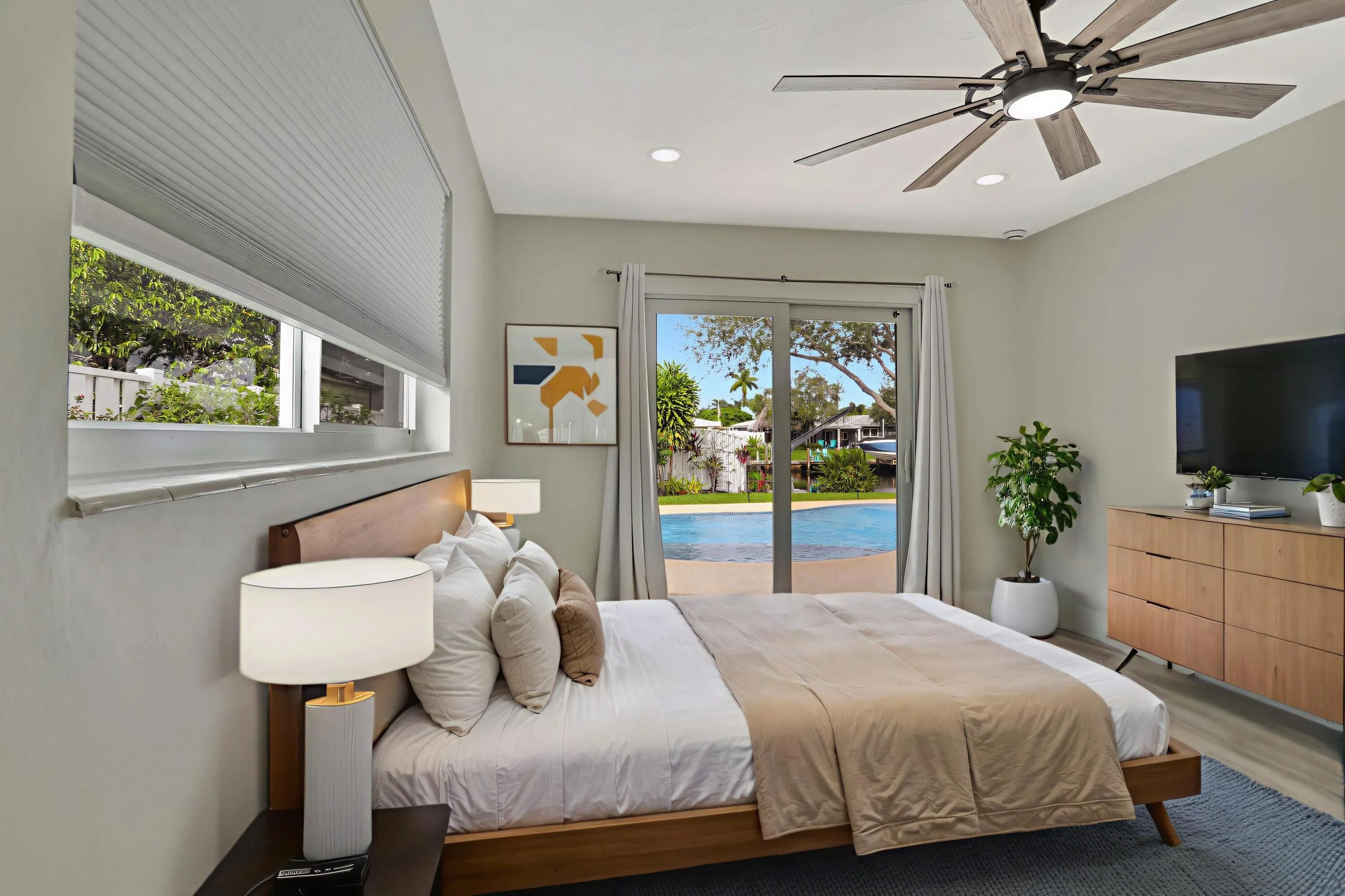 Bedroom facing the pool/ water can be Primary Suite or Bedroom #2. Both bedrooms are on suites. Storm sliders lead to the pool/deck. This photo is virtually staged.