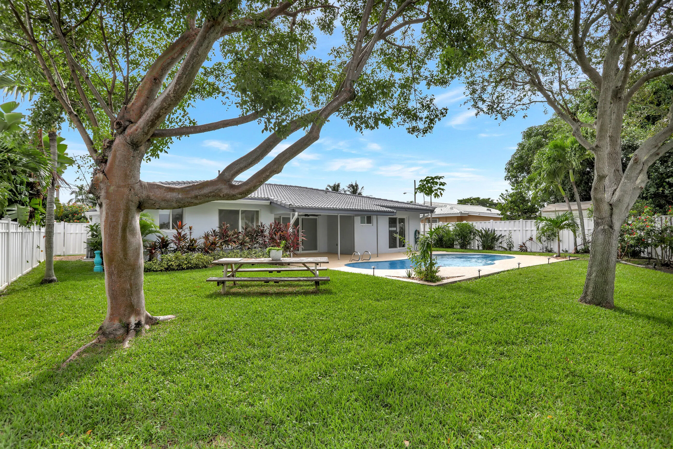 Large yard with privacy fence on both sides, water view and pool, deck and covered patio. Room to add a bedroom.