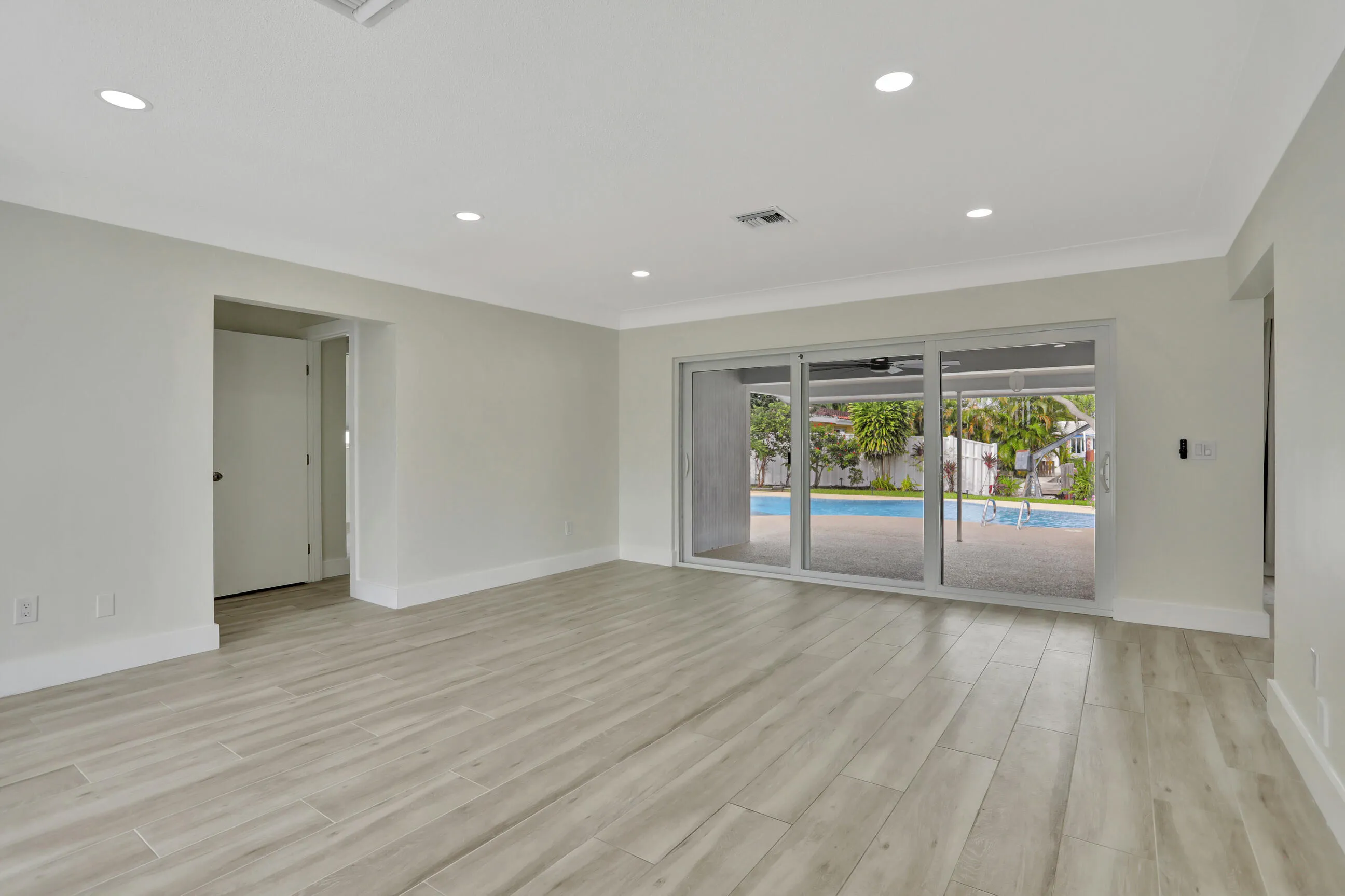 Living room leading to the pool and patio.