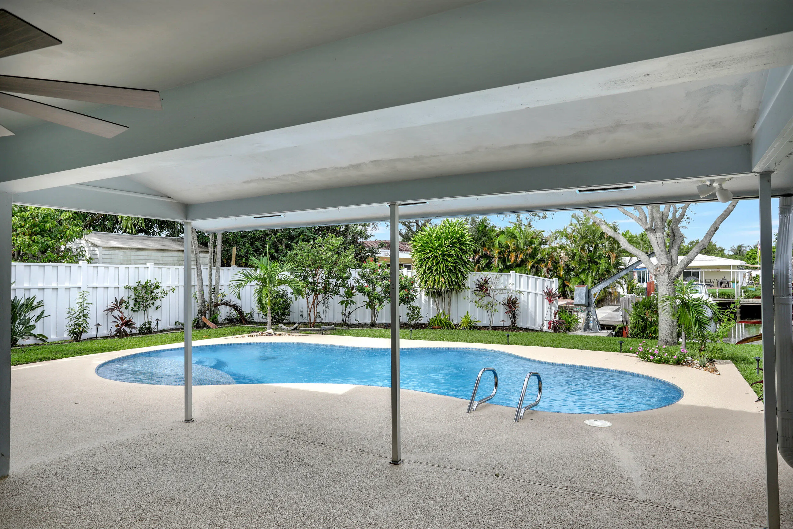 Covered patio looking at the pool , deck and water.