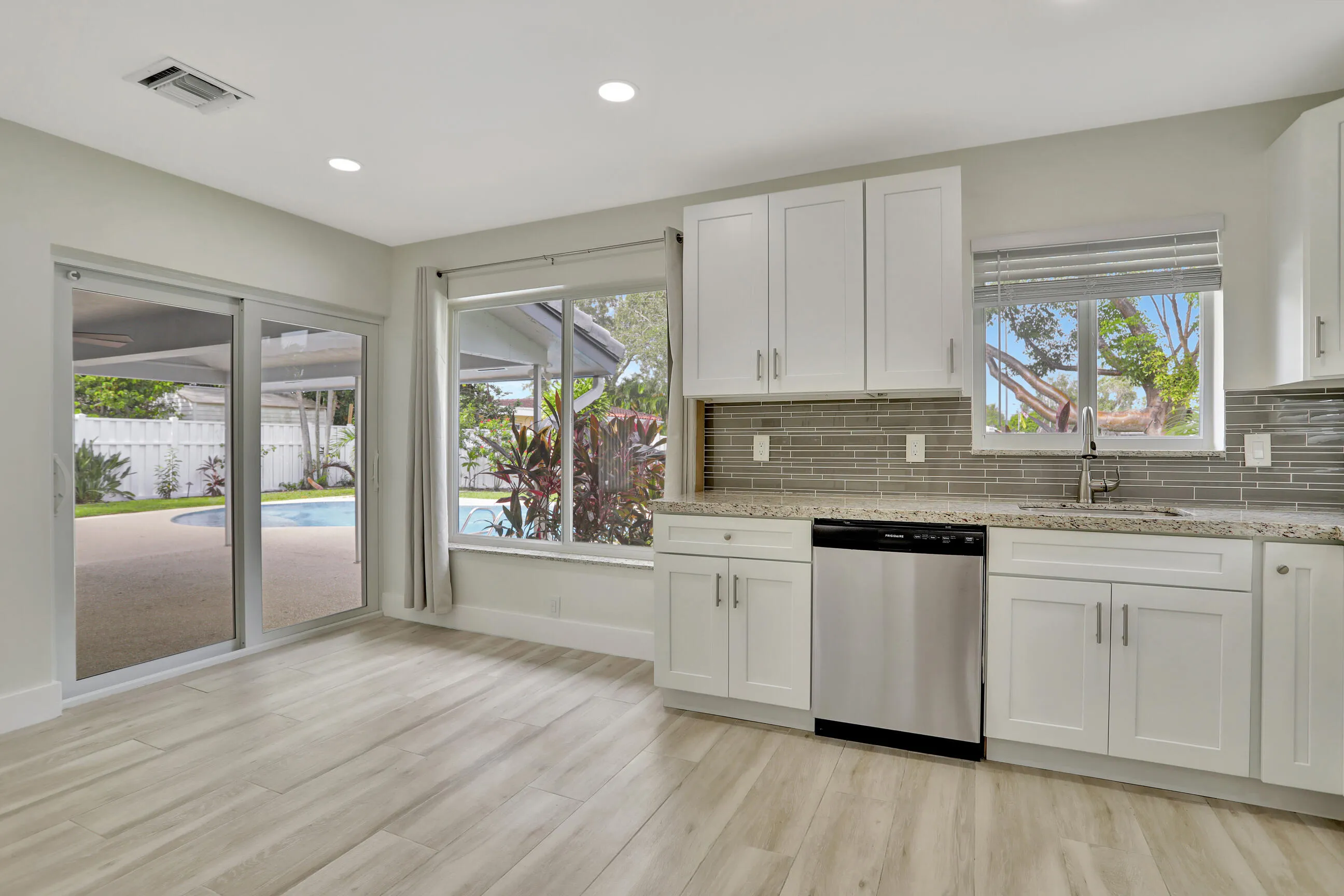 Dining area near kitchen has picture window water views with storm windows and sliders leading to the covered patio, pool and deck.