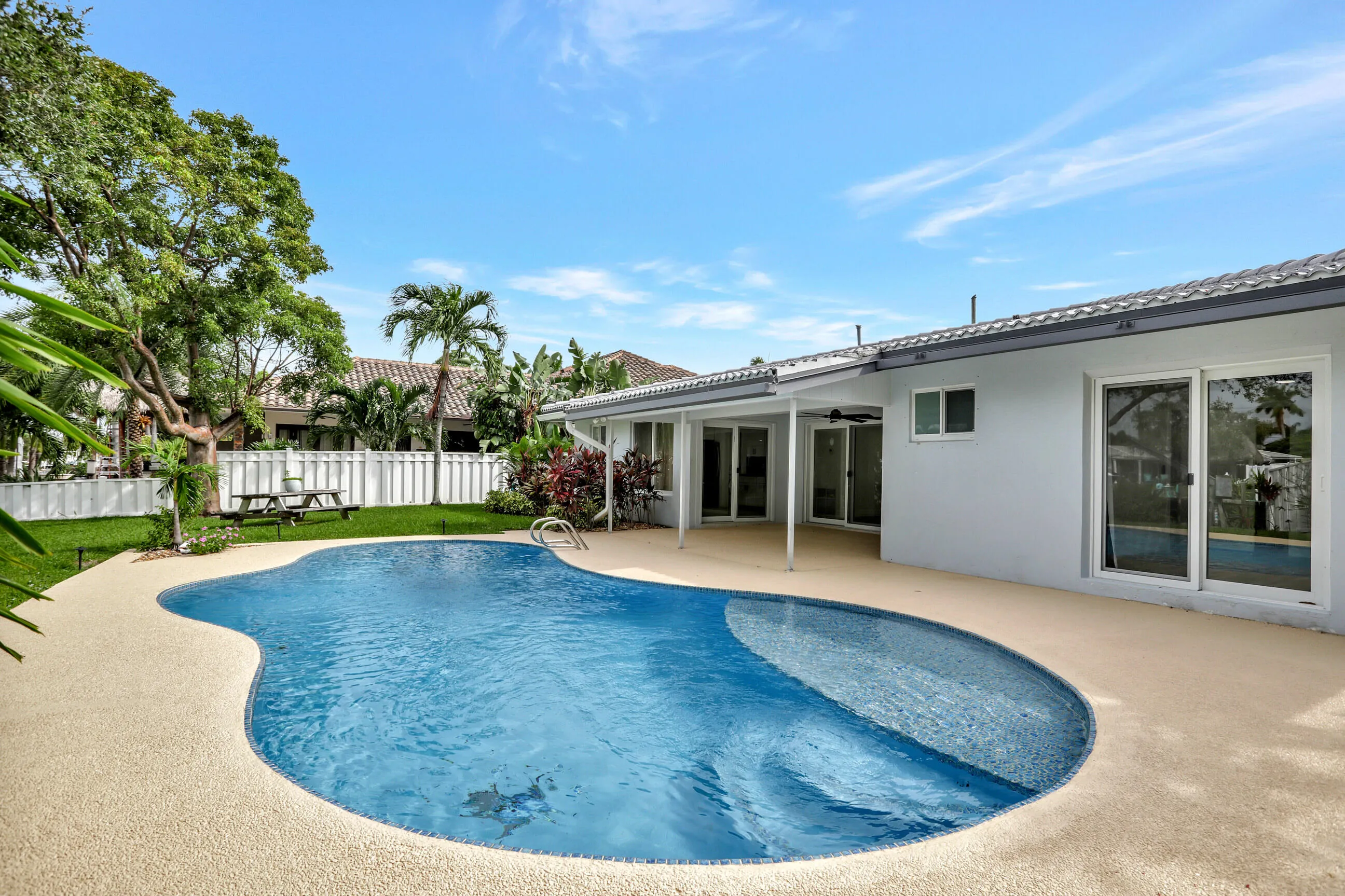 Wonderful pool and deck with covered porch and access to the pool from the Primary Suite on the right.
